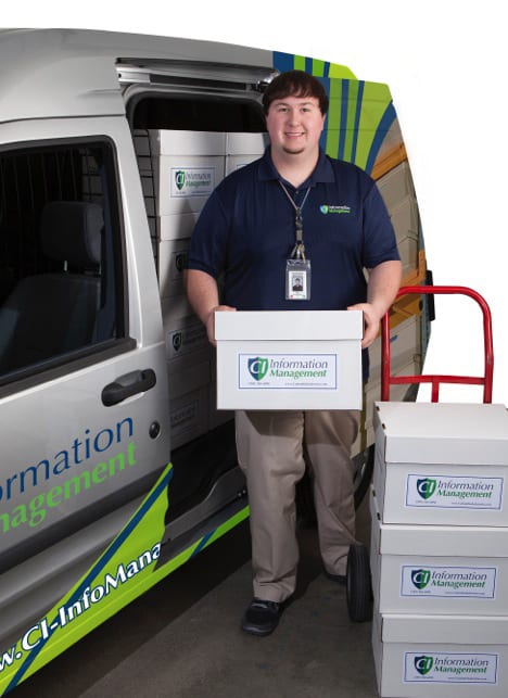 A CI Information Management Employee loading records storage boxes in a pickup van