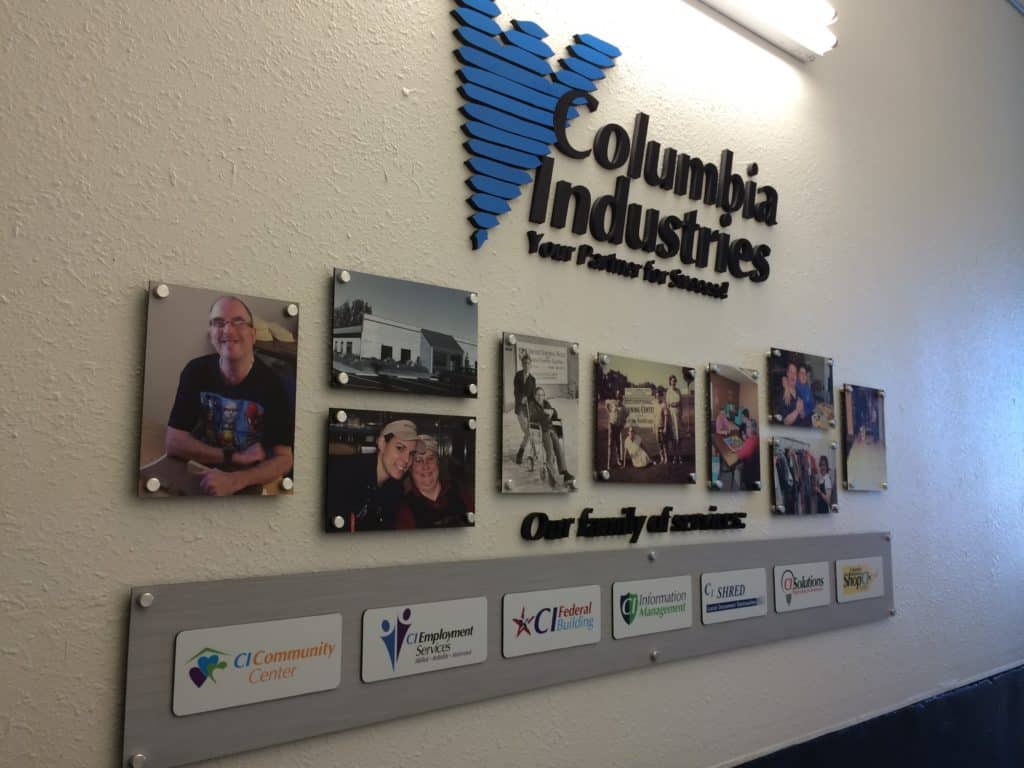 A Columbia Industries wall showcasing photos and logos of the services.