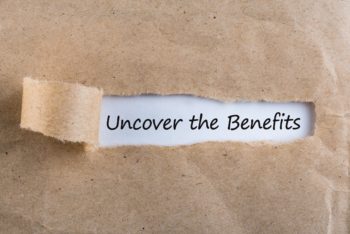 Uncover The Benefits text on brown envelope. Word Uncover The Benefits on torn paper. Concept Image..