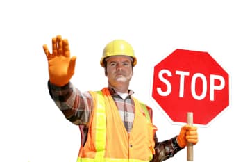 A construction worker holding up a stop sign.