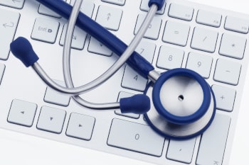 A stethoscope sitting on a computer keyboard.