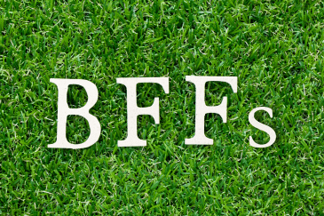 Wood letter blocks spelling "BFFs" on green grass