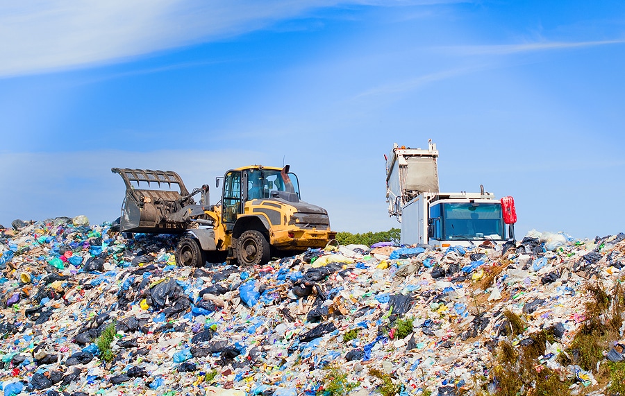 a garbage truck unloading at a landfill